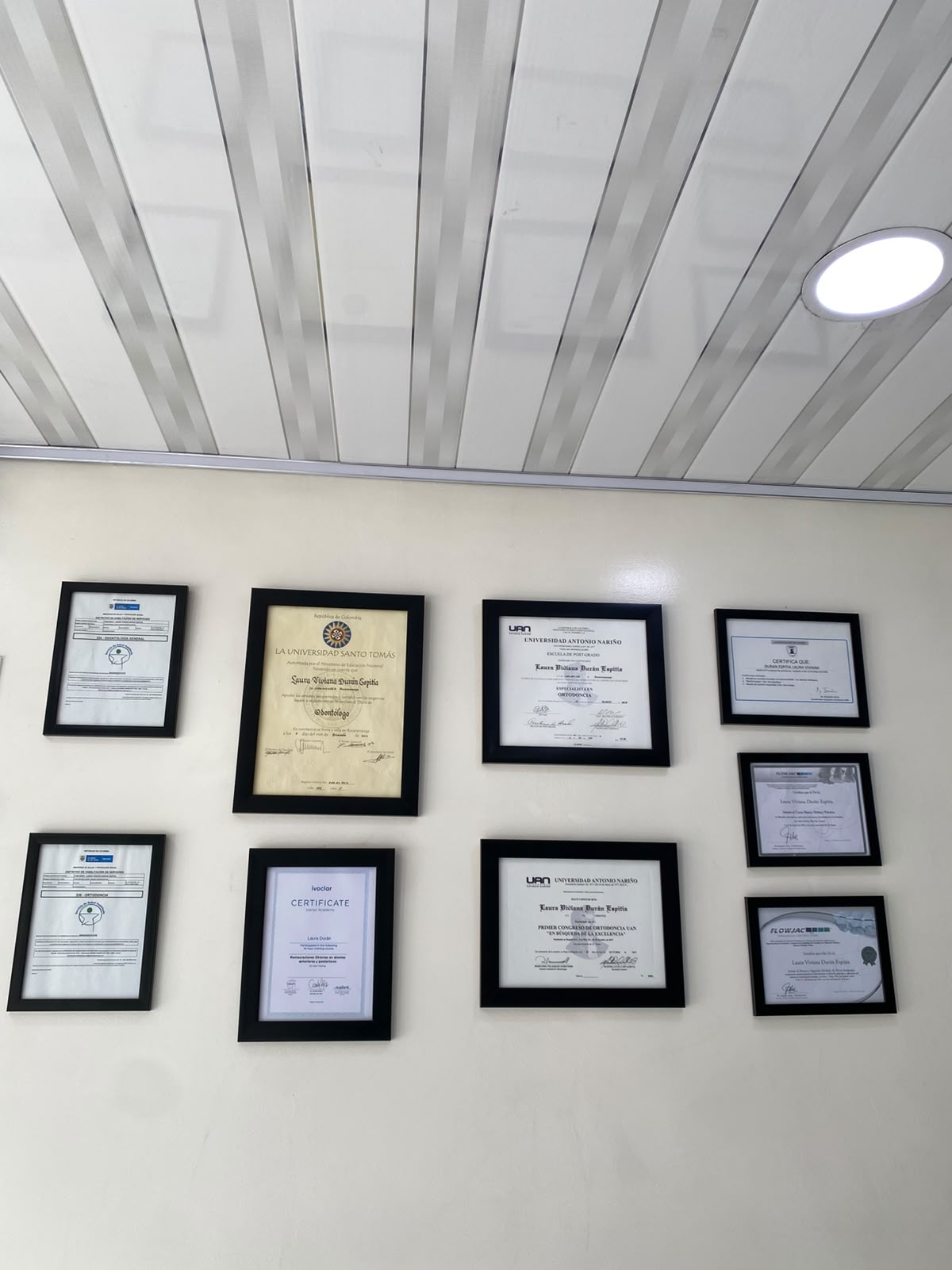 Diplomas y certificaciones profesionales exhibidos en el consultorio